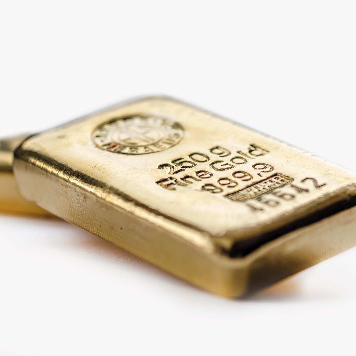 Two cast gold bars on a grey background.