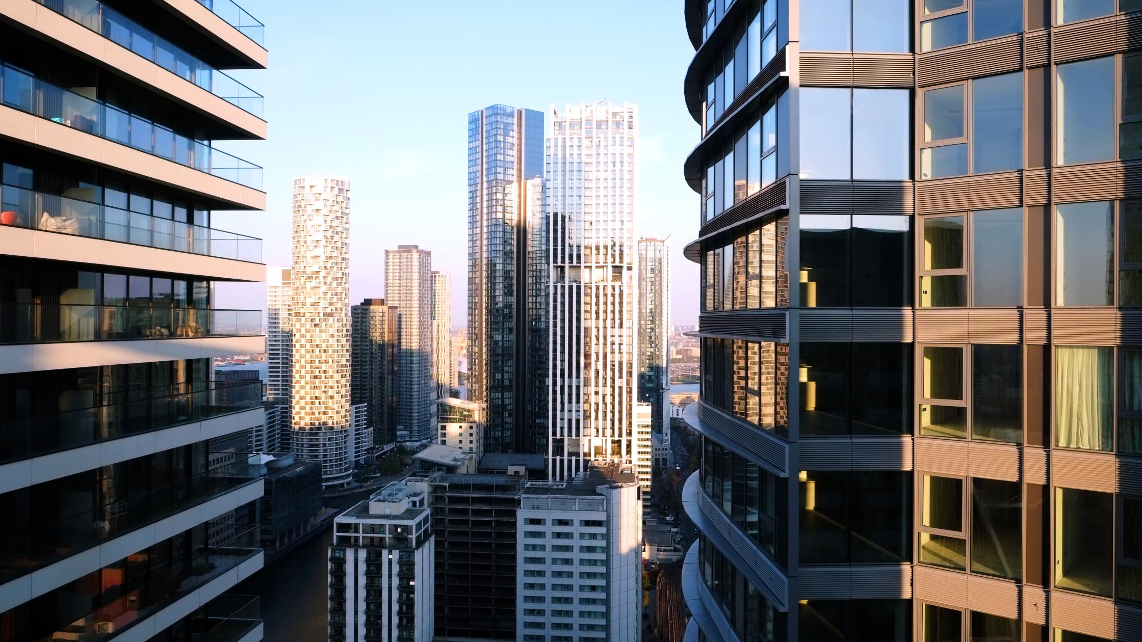 UK, London, Canary Wharf, elevated view over city skyline in Canary Wharf illuminated at sunset.