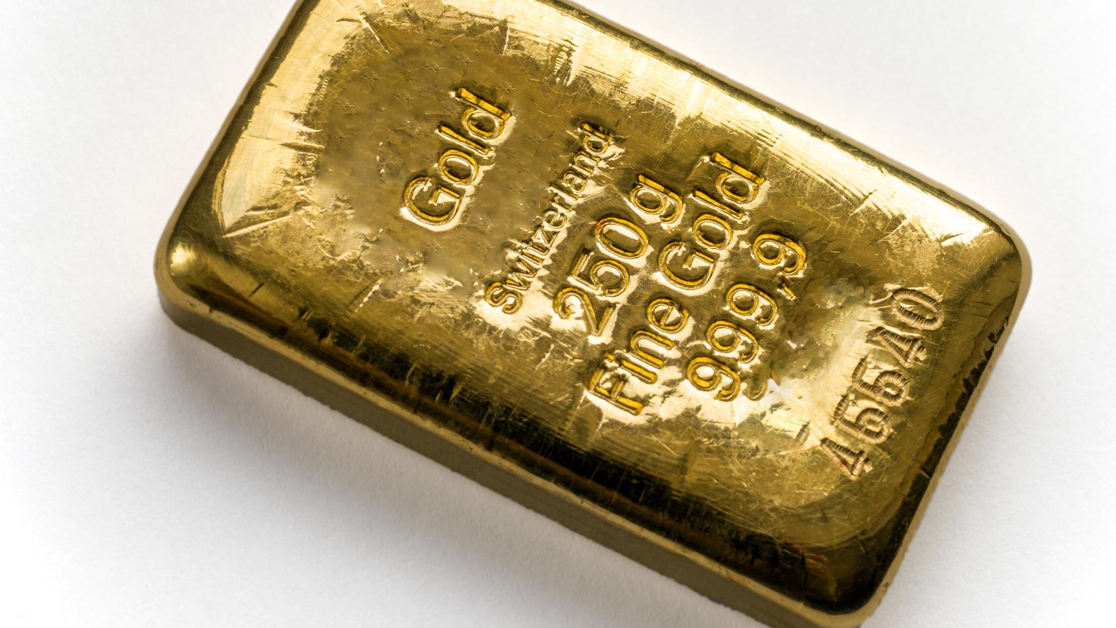 Three cast gold bars are in a pile. Isolated on a white background.