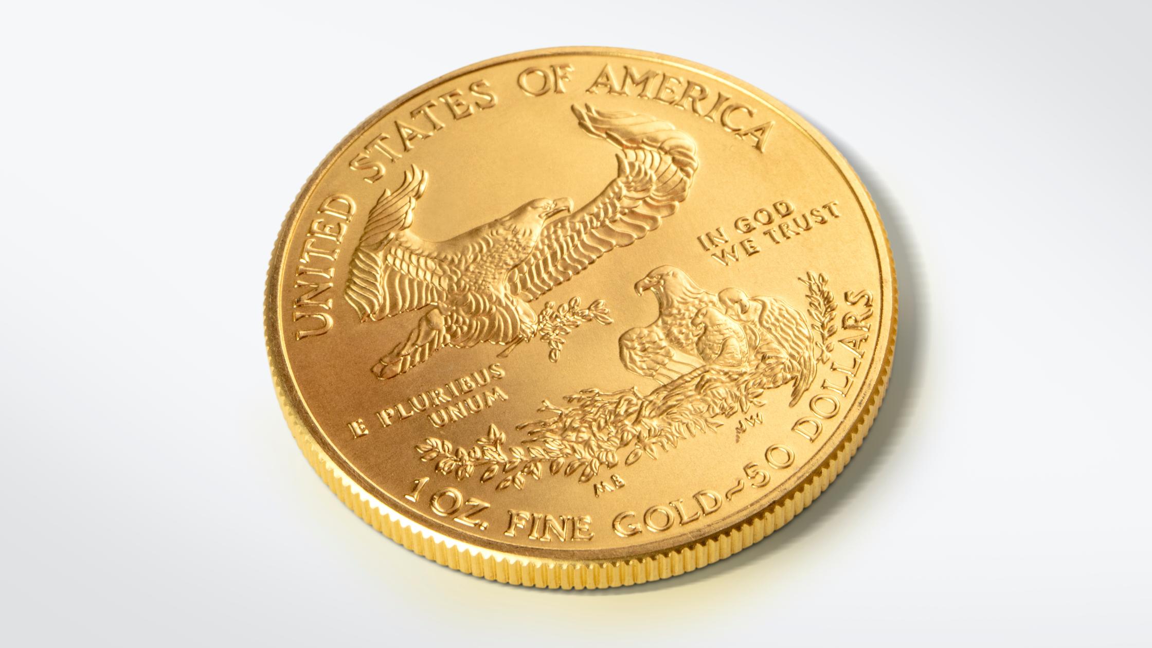 golden american eagle one ounce coin laying on a heap of golden nuggets, golden ore on white background isolated with plenty copy space.